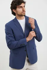 Saco azul de lino, de corte clásico, con solapa de muesca, cierre de dos botones, bolsillos frontales con solapa y aberturas traseras.