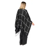 Poncho de tejido de punto con diseño de cuadros grandes en contraste negro y gris, con terminación de flecos en el ruedo.
