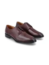 Zapato de vestir tipo derby color café, confeccionado en cuero con cierre de cordones y suela de goma con costura vista.