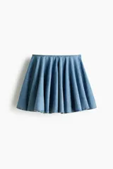 Pollera mini acampanada de denim de algodón rígido, con diseño amplio y fluido.