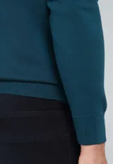 Sweater de algodón color verde petróleo, con cuello redondo y mangas largas.