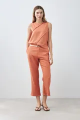 Pantalón capri color durazno de lino con efecto desflecado en el ruedo.