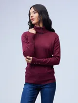 Polera gris de tejido fino con cuello alto y mangas largas con aplique de botones en los puños.