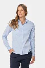 Camisa blanca de manga larga con cuello clásico y cierre frontal con botones.