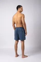 Short de baño de corte relajado en color gris azulado con efecto lavado. Cuenta con cintura elastizada con cordón ajustable, bolsillos laterales y una pequeña etiqueta decorativa en el ruedo.
