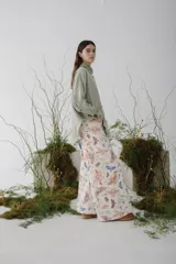 Pantalón jean de corte ancho con estampado de flores y mariposas en tonos pastel.