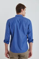 Camisa azul a rayas verticales, de corte clásico, con cuello abotonado y bolsillo en el pecho.