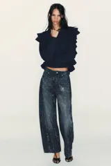 Jersey de punto color azul marino, con cuello redondo, manga larga y volantes decorativos en el frente y los hombros.