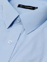 Camisa de corte regular fit, con cuello italiano, bolsillo en el pecho, cierre frontal abotonado y puños con botones.