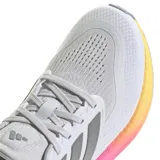 Championes de running Adidas Pureboost 5, con diseño en tonos gris claro, con entresuela que presenta un degradado de colores rosa y amarillo. Presentan el logo de la marca en la lengüeta y las icónicas tres bandas laterales en tono gris oscuro.