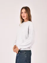 Buzo de cuello redondo en color gris melange, con diseño de corte holgado y mangas largas con puños elásticos.