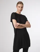 Blusa canalé asimétrica de manga corta y cuello redondo, color negro, con diseño largo y fluido.