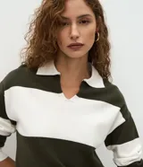 Suéter de punto con diseño de rayas horizontales anchas en color verde oscuro y blanco. Presenta cuello tipo polo con escote en V, mangas largas con puños ajustados y un corte regular.