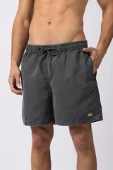 Short de baño de corte relajado en color gris azulado con efecto lavado. Cuenta con cintura elastizada con cordón ajustable, bolsillos laterales y una pequeña etiqueta decorativa en el ruedo.