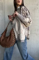 Sweater de punto con diseño abstracto de líneas orgánicas en tonos gris y beige, cuello redondo, manga larga con puños ajustados y corte holgado.