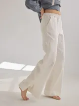 Pantalon de corte recto y tiro medio, confeccionado en lino, con cintura elastizada y tajos laterales en el ruedo.