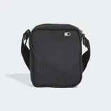 Bolso tipo morral Adidas de diseño minimalista, color negro, confeccionado en nylon reciclado. Presenta el logotipo del Trifolio en relieve en el frente, cierre de cremallera y correa ajustable para llevar al hombro o cruzado.