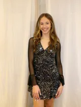 Vestido corto de encaje marrón, con escote en V, corte debajo del busto, mangas largas estilo trompeta y espalda transparente con volado en el ruedo.