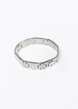 Pulsera de acero quirúrgico plateado con eslabones rectangulares y circulares.