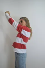 Sweater de algodón a rayas horizontales rojas y blancas, con cuello polo y cierre parcial con botones.