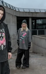 Remera de algodón color gris oscuro con efecto lavado, de corte holgado y manga corta. Presenta una estampa frontal detallada que muestra una serpiente entrelazada alrededor de una paleta de madera con corazones, rodeada por un diseño de alambre de púas.