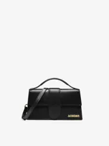 Bolso estructurado Jacquemus modelo Le Grand Bambino de cuero liso color negro, con asa superior, solapa frontal con cierre magnético, correa larga extraíble y logotipo metálico dorado.