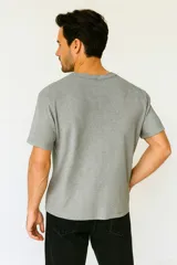 Remera de algodón gris de manga corta, con cuello redondo y textura acanalada.