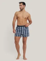 Pack de tres bóxers de algodón con cintura elástica con logo Tommy Hilfiger. Incluye un bóxer a cuadros azules y blancos, un bóxer negro con lunares blancos y un bóxer a cuadros verdes y azules.