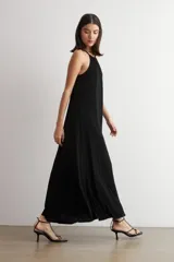 Vestido largo negro de lurex, con escote halter y diseño fluido y acampanado.