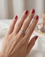 Anillo de plata 925 con diseño de corona y detalles de circonias cúbicas brillantes, acompañado por una alianza fina decorada con pequeñas piedras incrustadas.