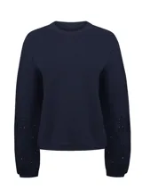 Buzo azul navy de algodón orgánico con cuello redondo, mangas largas voluminosas y delicados detalles bordados y calados de inspiración floral en las mangas.
