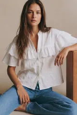 Blusa blanca de algodón con cuello mao, cierre frontal de botones y volados en los hombros con detalle de bordado inglés.