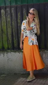 Falda midi evasé de raso color negro, con cintura elástica y cinturón con apliques metálicos.