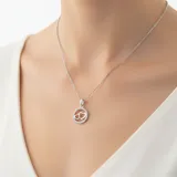 Collar de plata 925 con cadena fina y dije colgante. El dije consiste en un círculo exterior engastado con circonias y dos corazones entrelazados en el centro.