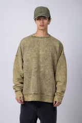 Buzo de cuello redondo con efecto de teñido artesanal acid wash. Presenta un corte oversize, mangas largas con puños acanalados y etiqueta pequeña en el puño izquierdo.