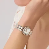 Reloj analógico de cuarzo con caja cuadrada de 25 mm y correa tipo brazalete de acero inoxidable en tono bicolor plateado y dorado rosado. La esfera blanca presenta un acabado sunray, detalles de cristales incrustados en el bisel y en el interior de la esfera, y manecillas en tono dorado rosado.