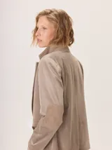 Blazer negro de simil terciopelo con cuello y puños en color marrón. Tiene bolsillos delanteros y forro estampado.