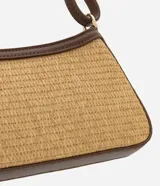 Cartera baguette color beige con efecto paja y detalles en cuero sintético marrón. Tiene correa de hombro ajustable y cierre por cremallera.