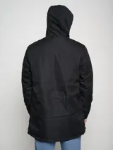 Parka larga gris con capucha, cierre frontal con cremallera y botones a presión, múltiples bolsillos y logo de Umbro en el pecho.