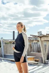 Conjunto de remera manga larga con protección UV, color negro con mangas color beige, y calza corta color negro.