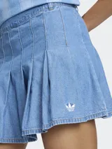 Minifalda plisada de denim azul, de talle medio, con diseño inspirado en la estética futbolística retro y cierre de cremallera.