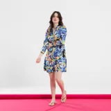 Vestido corto con estampado paisley en tonos verde, celeste y naranja. Tiene cuello mao, mangas 3/4 y corte evasé.