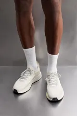 Zapatilla deportiva de correr color caqui, con capellada de tejido de punto transpirable y ajuste con cordones. Cuenta con refuerzos Shield Protect Max en puntera y talón, tirador trasero, plantilla OrthoLite® y entresuela Spume Foam V3.