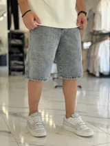 Bermuda de jean de corte baggy y tiro medio, con diseño clásico de cinco bolsillos y lavado claro.