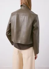 Chaqueta Sabi de cuero sintético en color verde militar, con cuello camisero, cierre frontal con botones y bolsillos de parche delanteros.