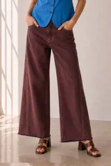 Jeans modelo Rul de corte wide leg en color bordó con efecto gastado, tiro alto y terminación desmechada en el bajo.