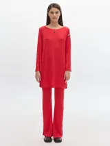 Pantalón de terciopelo rojo, corte flare, con cintura elástica y aberturas en el ruedo.