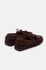 Mocasín de gamuza color bordó con detalle de flecos, cordones y tachas metálicas en la parte superior.