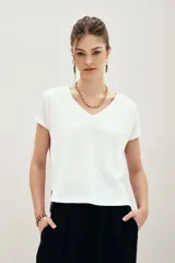 Remera blanca de algodón con cuello en V, mangas cortas y calce relajado.