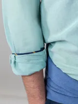 Camisa celeste de corte clásico, con cuello abotonado, manga larga y logo bordado en el pecho.